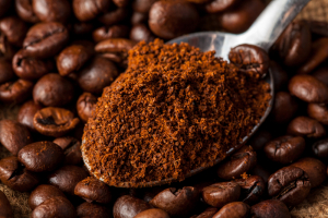 spoon with ground and grain coffee